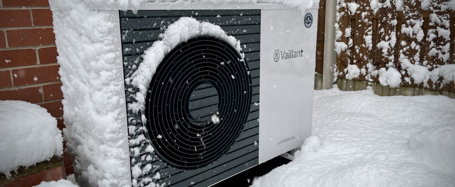 Vaillant Arotherm heat pump in snow outside 1930s Sheffield semi-detached home